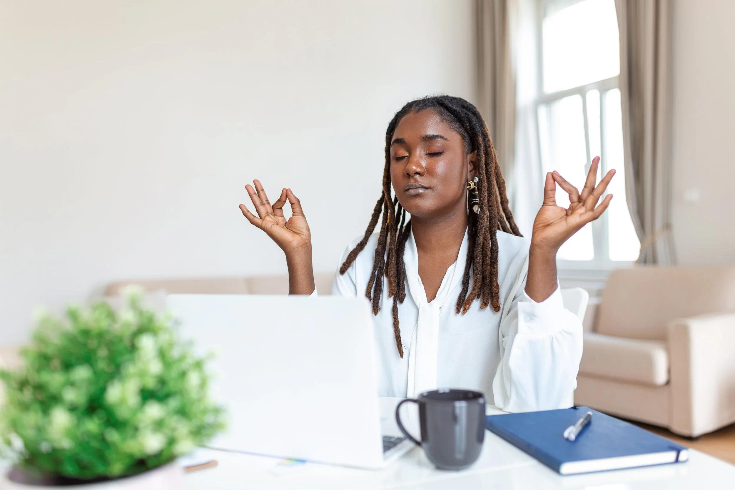 Woman meditating at work, practicing mindful pause